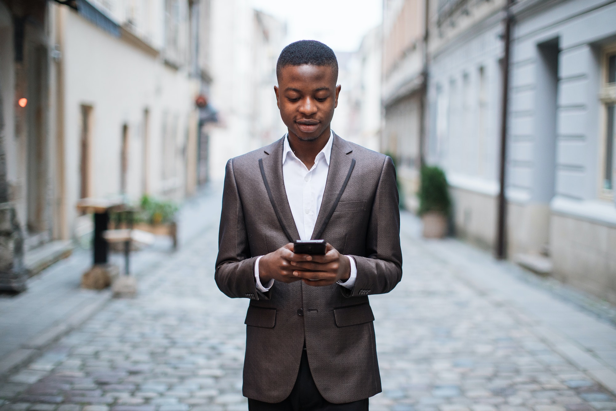 African businessman using smartphone on street